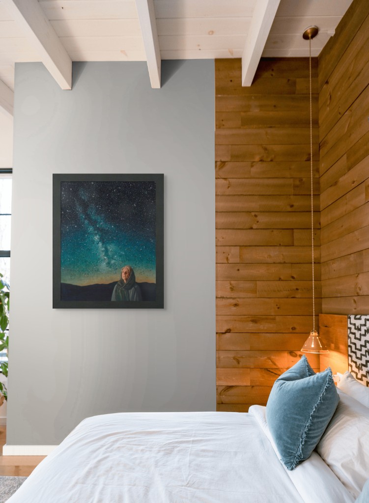 Print on a gray wall next to rustic wood paneling in a bedroom
